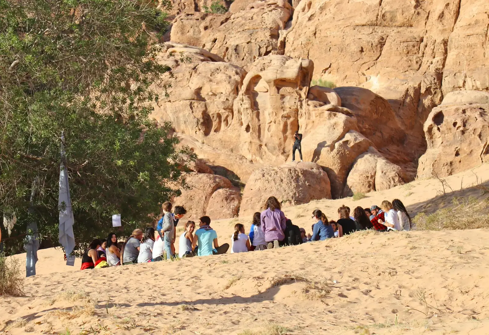 A long line of people walking among desert rock formations